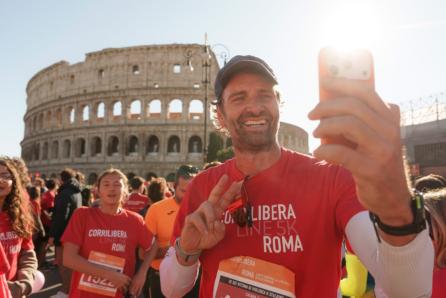 Un partecipante sorride mentre scatta una foto con il Colosseo sullo sfondo